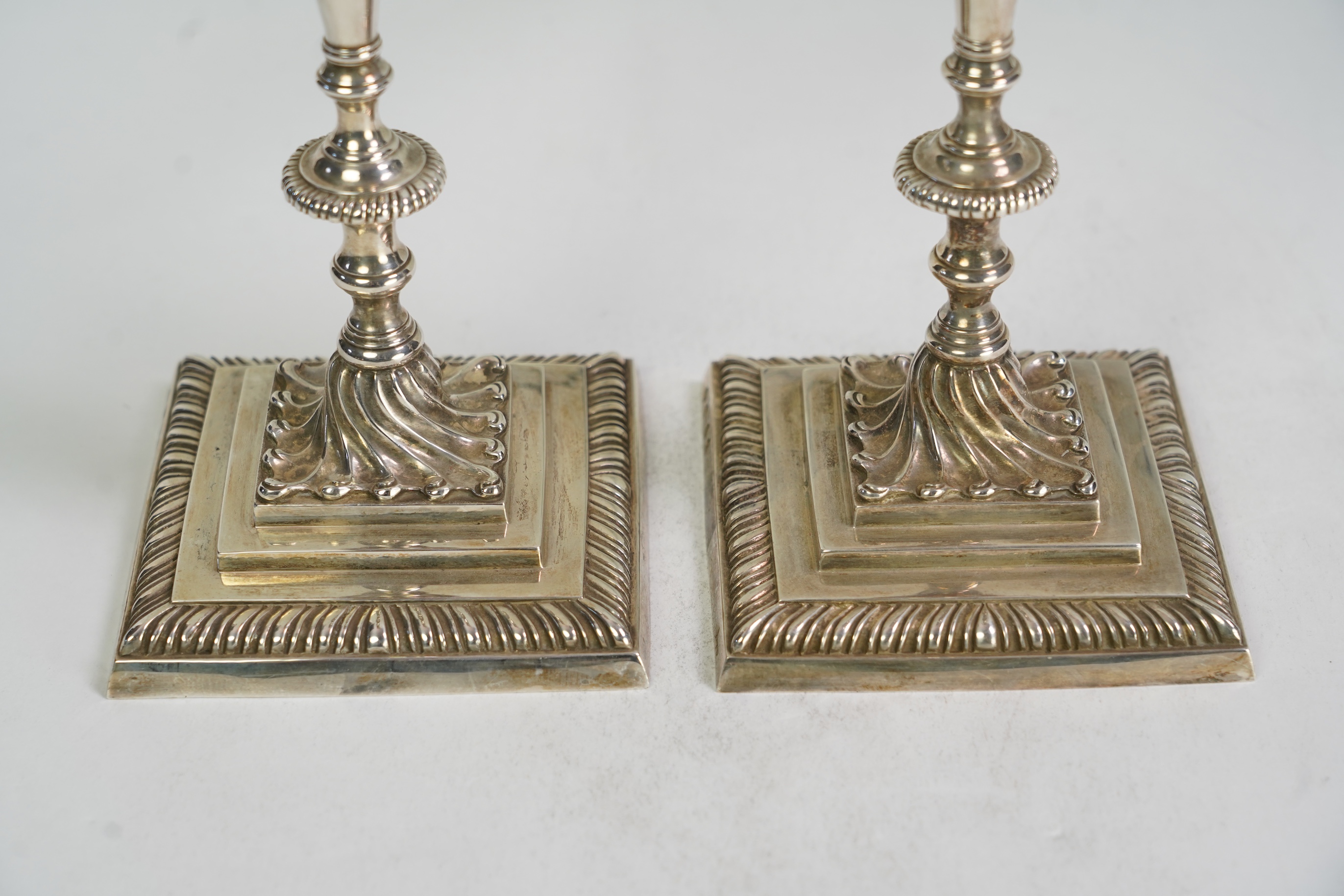 A pair of Elizabeth II 18th century style Asprey & Co cast silver candlesticks